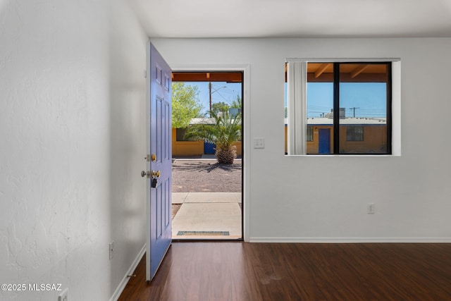 doorway with wood finished floors and baseboards