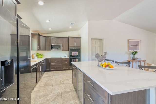 4921 N Boyd Ln, Tucson, AZ 85750 - kitchen with visible vents, dark brown cabinets, a center island, vaulted ceiling, and stainless steel appliances