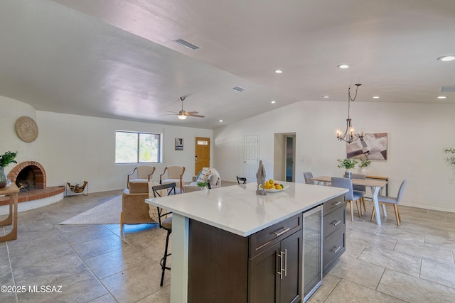 4921 N Boyd Ln, Tucson, AZ 85750 - kitchen featuring a breakfast bar area, visible vents, a center island, vaulted ceiling, and beverage cooler
