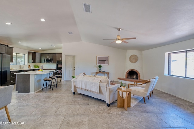 4921 N Boyd Ln, Tucson, AZ 85750 - living area featuring a large fireplace, a ceiling fan, baseboards, lofted ceiling, and visible vents