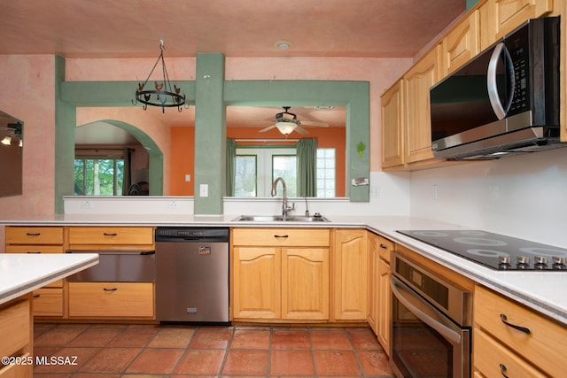 kitchen with a healthy amount of sunlight, light countertops, a sink, a warming drawer, and stainless steel appliances