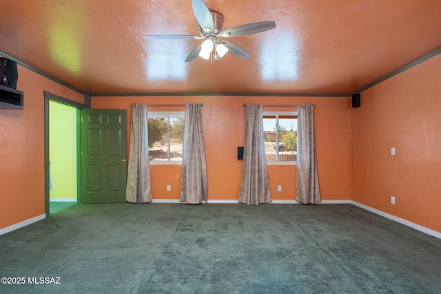 carpeted spare room featuring baseboards, ceiling fan, crown molding, and a wealth of natural light