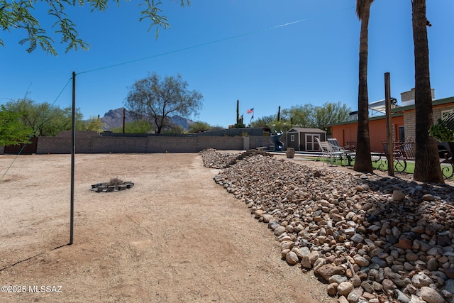 view of yard with an outdoor structure, a fenced backyard, and a storage unit