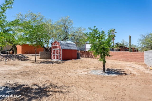 view of yard featuring fence private yard, an outbuilding, and a storage shed
