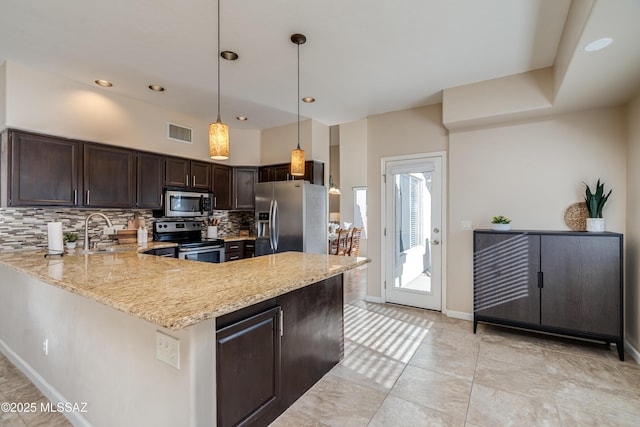10261 N Wild Turkey Ln, Oro Valley, AZ 85737 - kitchen featuring backsplash, visible vents, dark brown cabinets, light stone counters, and stainless steel appliances