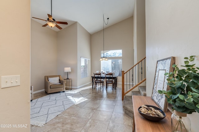 10261 N Wild Turkey Ln, Oro Valley, AZ 85737 - foyer with baseboards, ceiling fan with notable chandelier, high vaulted ceiling, and stairway