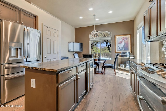 kitchen featuring a center island, a notable chandelier, wine cooler, stainless steel appliances, and recessed lighting
