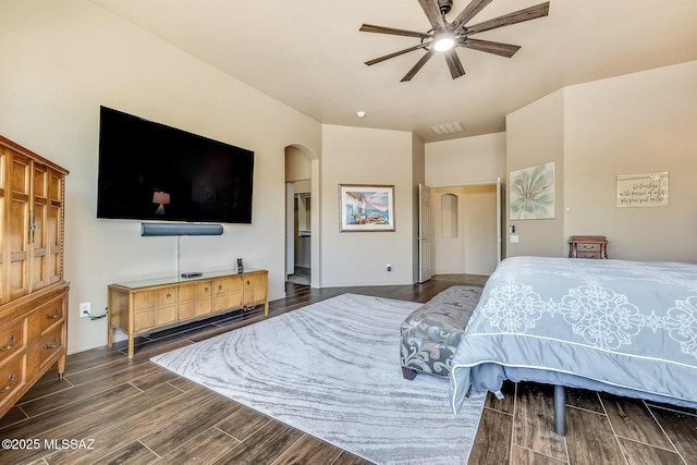 bedroom featuring arched walkways, a ceiling fan, wood finished floors, and visible vents
