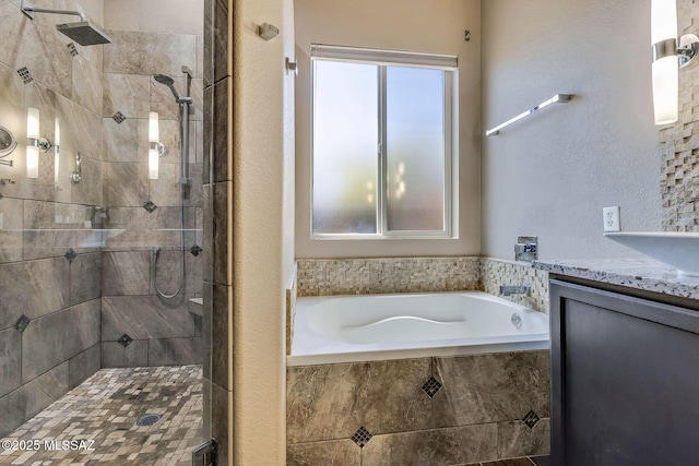 full bathroom with a textured wall, a tile shower, a garden tub, and vanity