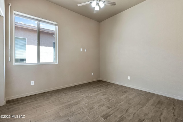 empty room with baseboards, ceiling fan, and wood finished floors