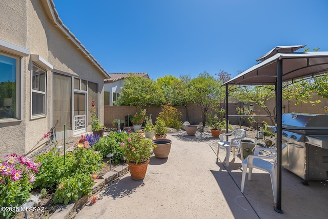 view of patio featuring a fenced backyard, a gazebo, and a grill