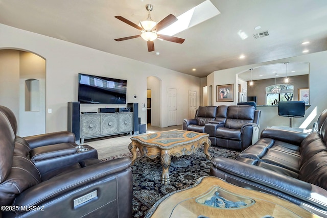 living room featuring visible vents, arched walkways, and a ceiling fan