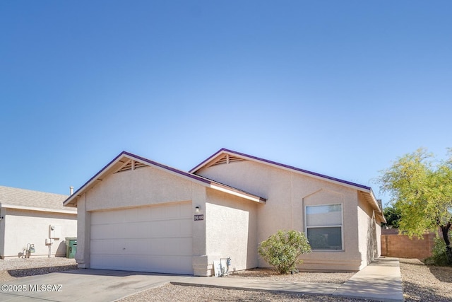 ranch-style house with concrete driveway, a garage, stucco siding, and fence