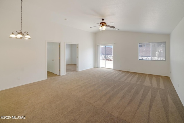 unfurnished living room with ceiling fan with notable chandelier, light carpet, and high vaulted ceiling
