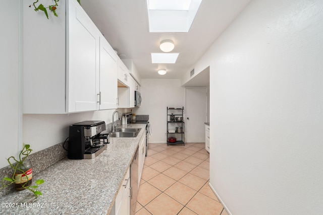 kitchen with visible vents, a skylight, appliances with stainless steel finishes, a sink, and white cabinets