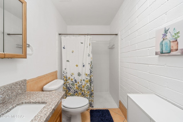 bathroom featuring vanity, tile patterned flooring, toilet, and tiled shower
