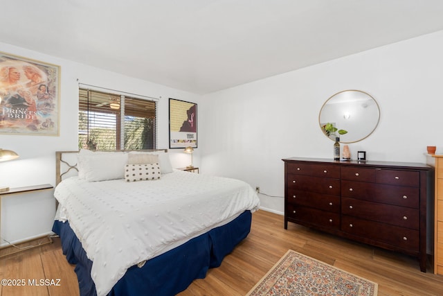 bedroom with baseboards and wood finished floors