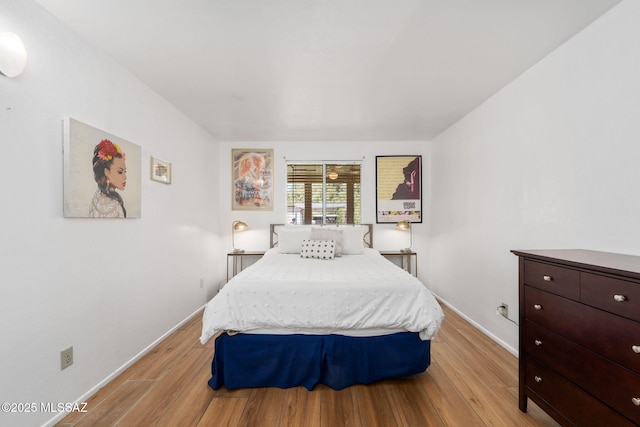 bedroom featuring light wood-style floors and baseboards
