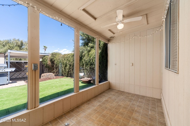 unfurnished sunroom featuring ceiling fan