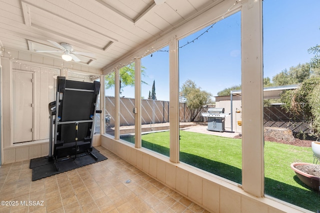 unfurnished sunroom featuring a ceiling fan