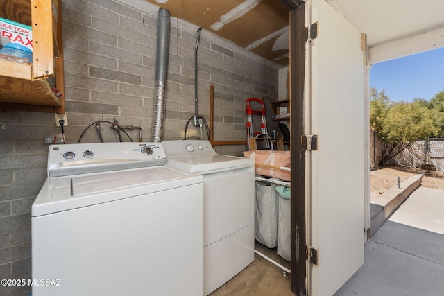 laundry area featuring separate washer and dryer and concrete block wall