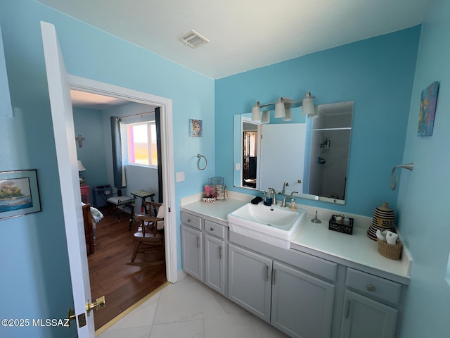 bathroom with walk in shower, marble finish floor, visible vents, and vanity
