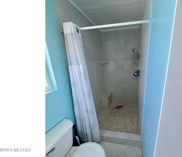 full bath with toilet and tiled shower