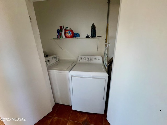 laundry room with washer and dryer, laundry area, and dark tile patterned flooring