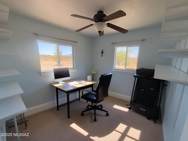 office area with baseboards, light carpet, and a ceiling fan