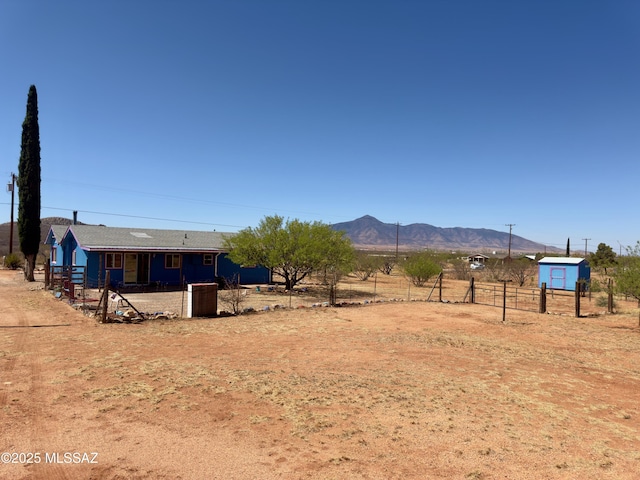 view of yard with a mountain view, fence, and a rural view