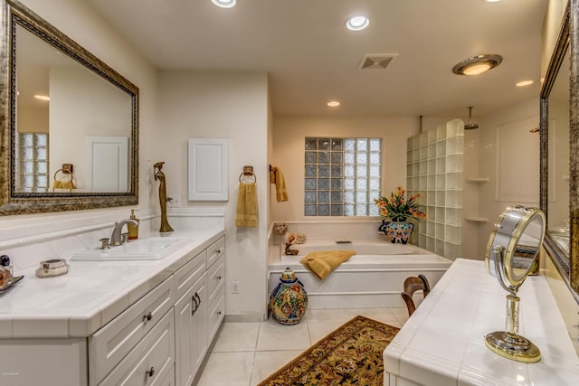 full bathroom featuring visible vents, vanity, walk in shower, a bath, and tile patterned floors