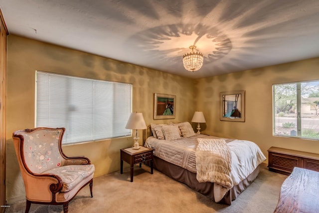 bedroom featuring a chandelier and light carpet