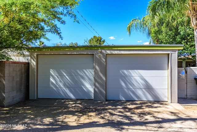 detached garage featuring fence