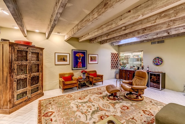 living area featuring brick floor, beamed ceiling, and visible vents