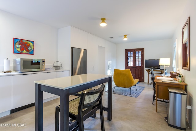 2626 E 4th St, Tucson, AZ 85716 - kitchen with concrete flooring, appliances with stainless steel finishes, white cabinetry, and modern cabinets