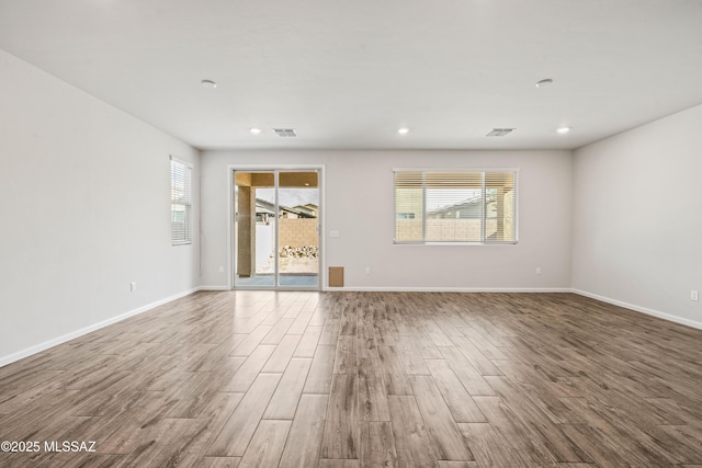 unfurnished room featuring recessed lighting, baseboards, visible vents, and wood finished floors