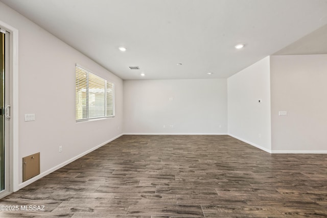 empty room with dark wood-style flooring, baseboards, recessed lighting, and visible vents