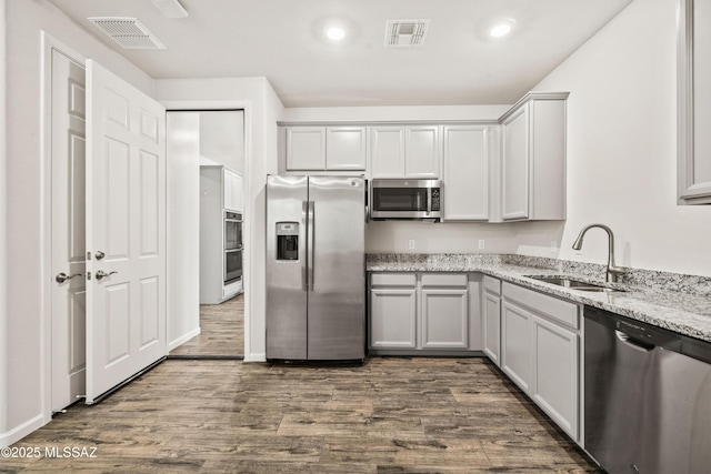 kitchen with visible vents, a sink, dark wood finished floors, and stainless steel appliances