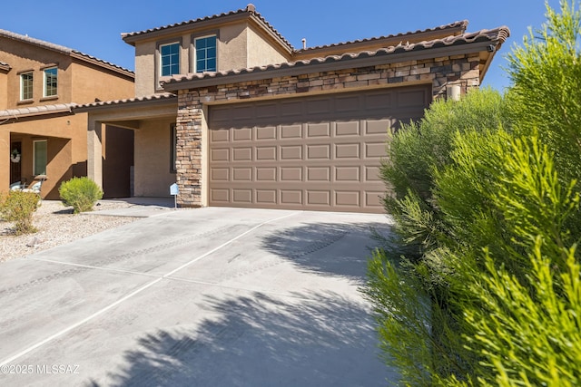 mediterranean / spanish home with a tiled roof, stucco siding, driveway, and stone siding