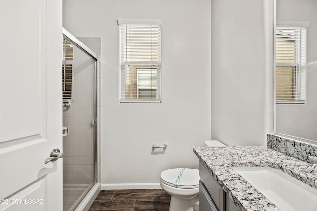 bathroom with vanity, baseboards, a stall shower, and toilet
