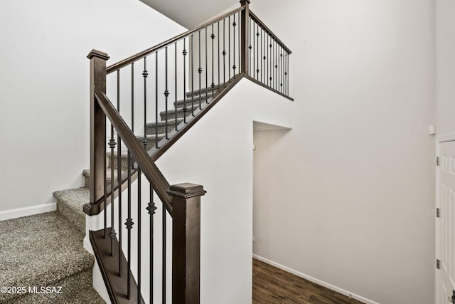 staircase featuring baseboards and wood finished floors