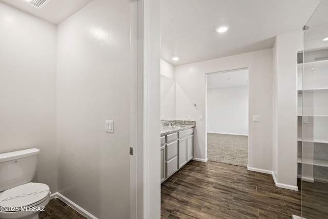 bathroom with baseboards, wood finished floors, and vanity