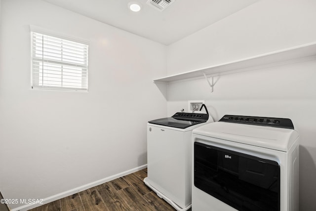 laundry room with laundry area, visible vents, baseboards, dark wood-type flooring, and washer and dryer