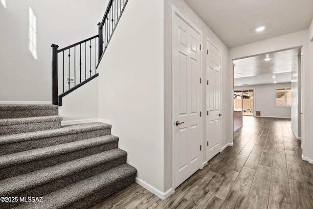 staircase with recessed lighting, baseboards, and wood finished floors