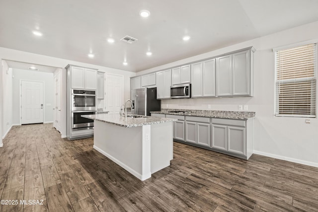 kitchen featuring appliances with stainless steel finishes, baseboards, dark wood-style flooring, and visible vents
