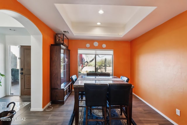 13960 E Placita Simpatica, Vail, AZ 85641 - dining room featuring a tray ceiling, dark wood-style flooring, arched walkways, baseboards, and recessed lighting