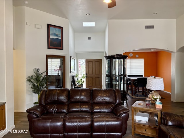 13960 E Placita Simpatica, Vail, AZ 85641 - living area featuring arched walkways, wood finished floors, plenty of natural light, a high ceiling, and baseboards