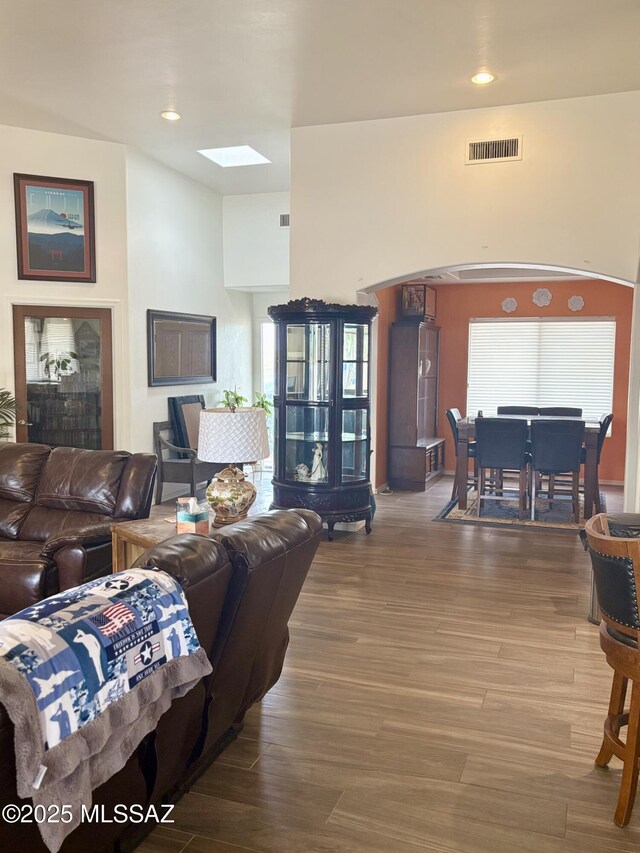 13960 E Placita Simpatica, Vail, AZ 85641 - living room featuring arched walkways, wood finished floors, a towering ceiling, and baseboards