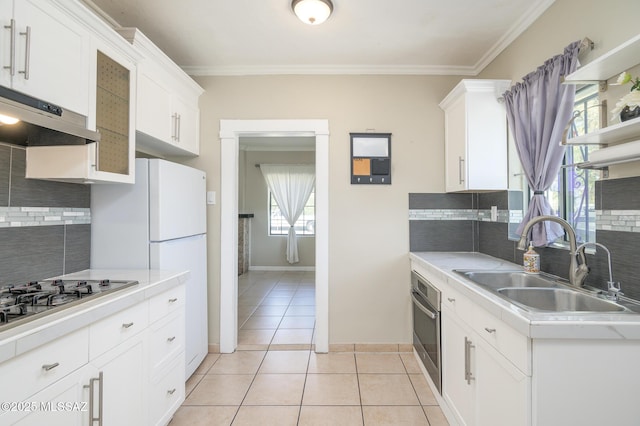 1025 N Perry Ave, Tucson, AZ 85705 - kitchen with decorative backsplash, a sink, appliances with stainless steel finishes, light countertops, and under cabinet range hood