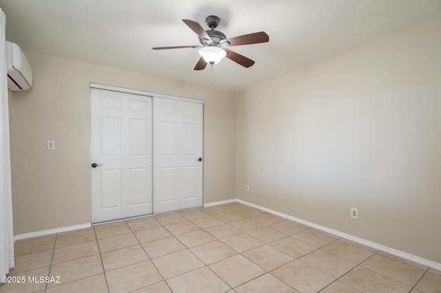 1025 N Perry Ave, Tucson, AZ 85705 - unfurnished bedroom with a wall mounted air conditioner, a closet, ceiling fan, light tile patterned flooring, and baseboards